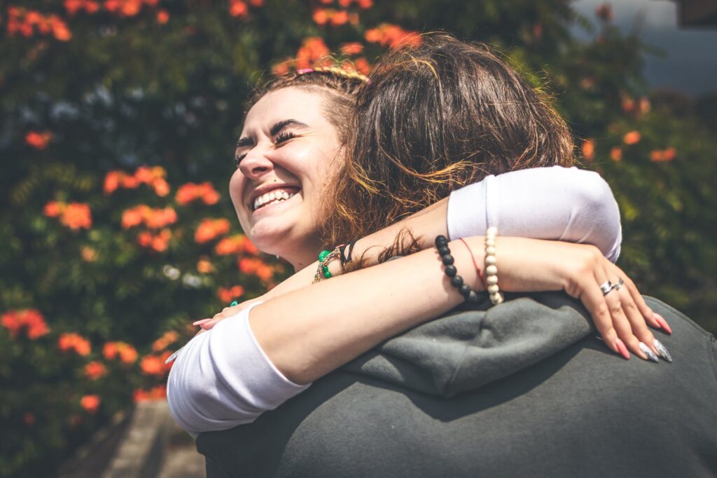 Mighty Women | Are you stressed?, build and maintain relationships, happy, smiling, hug, friends, young women, excited,Make an impact, women hugging